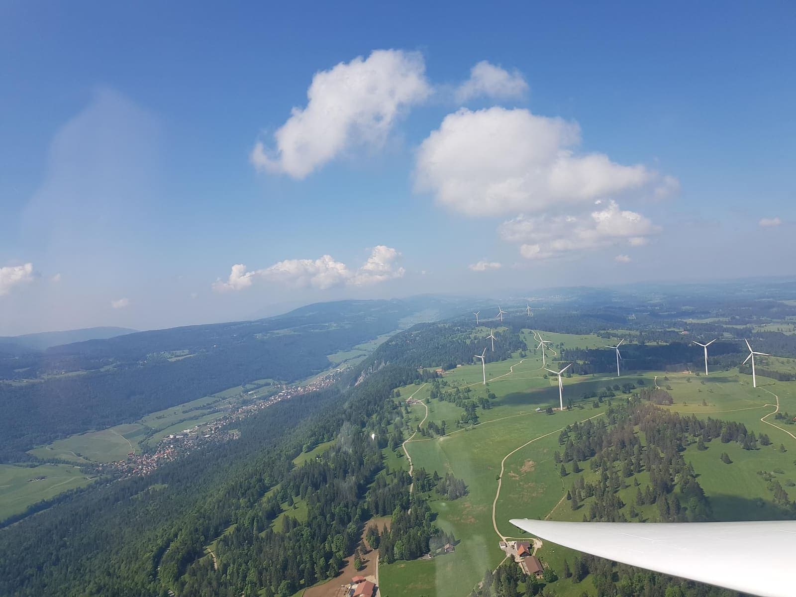 Der bewaldete Jurakamm mit Windrädern kurz nach dem Start in Courtelary
