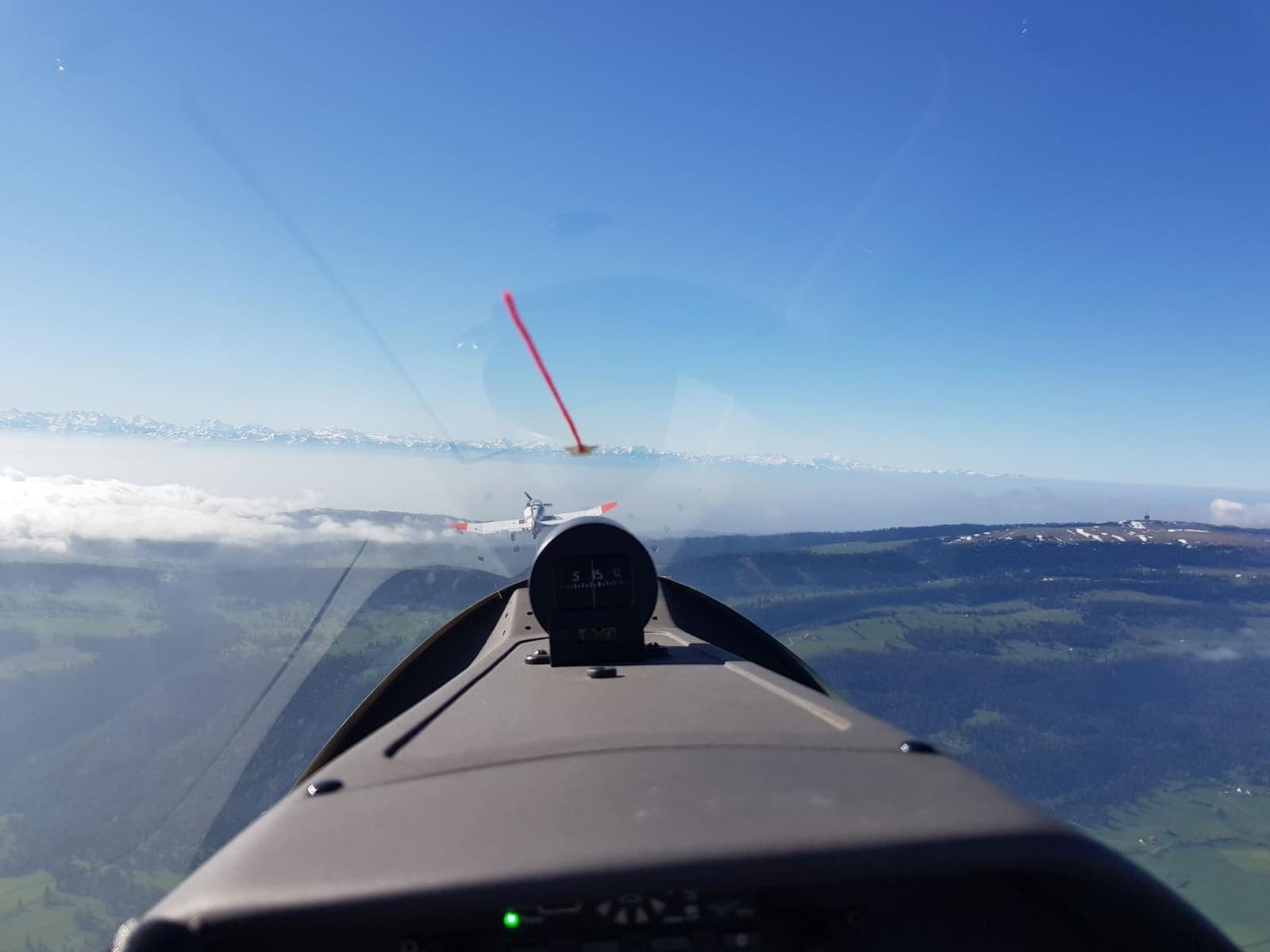 Cockpit view over a closed fog layer at the Swiss border in the early morning